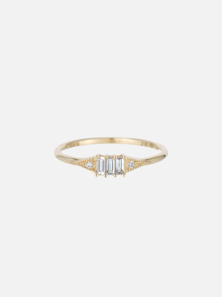 A gold ring with three rectangular diamonds in the center and small round diamonds on each side.