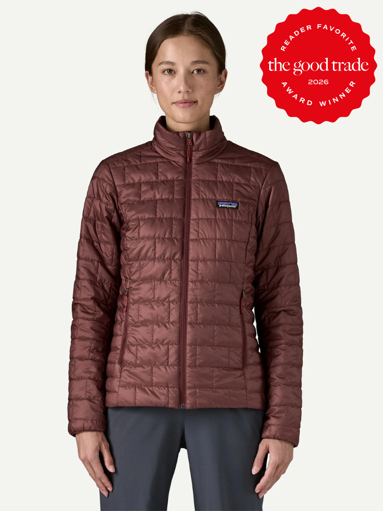 A woman wearing a maroon quilted jacket stands facing forward. A red badge in the corner reads "The Good Trade Award Winner 2026 Reader Favorite.